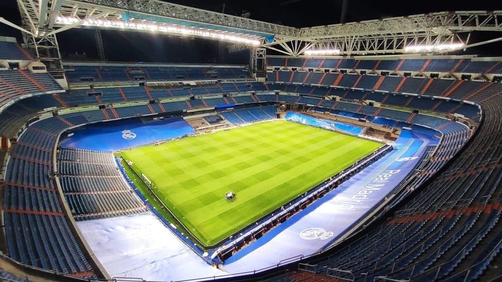 Estadio de fútbol con iluminación y césped bien cuidado, preparado para un partido importante.