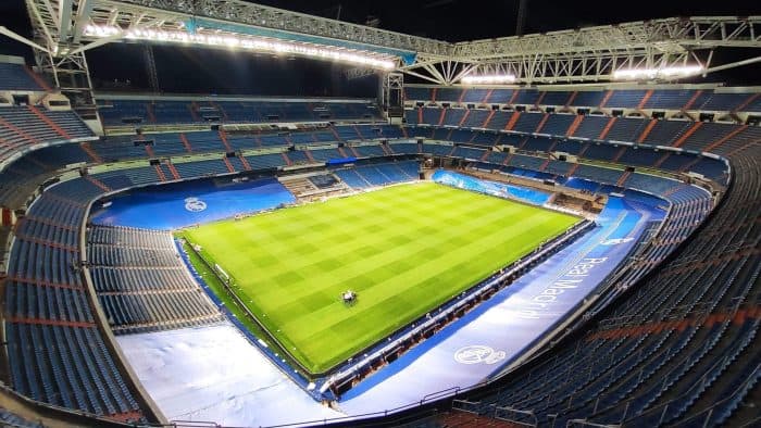 Estadio de fútbol con iluminación y césped bien cuidado, preparado para un partido importante.